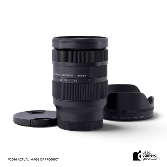 usedcameragear Sigma 28-70mm f/2.8 DG DN Contemporary lens for Sony FE with lens hood and caps on white background