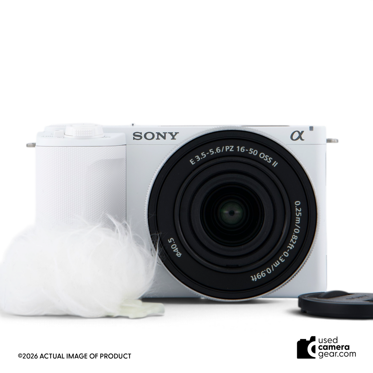 Used Sony ZV-E10 II mirrorless camera in white with 16-50mm power zoom lens and wind muff, front view.