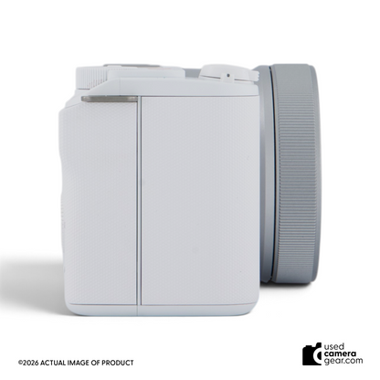 Usedcameragear white Sony ZV-E10 II mirrorless camera with 16-50mm lens, side view showing compact body design.
